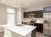 Thumbnail 31 of 48 - a kitchen with stainless steel appliances and a white counter top