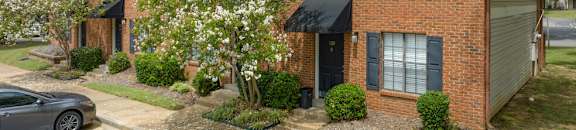 a brick house with a tree in front of it