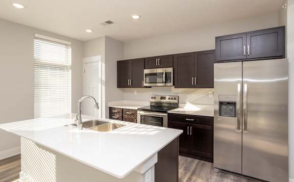 a kitchen with stainless steel appliances and a white counter top