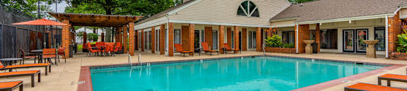 a swimming pool in front of a house with a resort style pool
