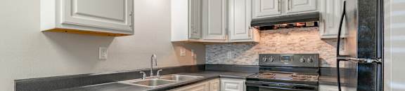 a kitchen with black appliances and white cabinets
