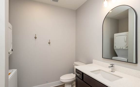 a bathroom with a mirror and a sink and a toilet