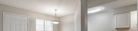 an empty living room and kitchen with a white door