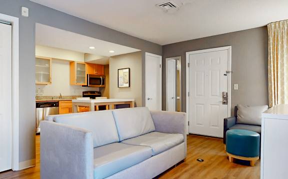a living room and kitchen with a couch and a chair