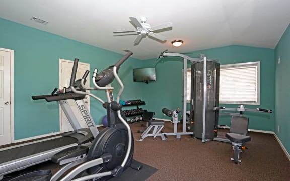 a gym with a ceiling fan and exercise equipment