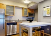 Thumbnail 12 of 16 - a kitchen with a island and a stainless steel refrigerator
