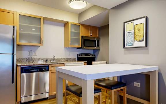 a kitchen with a island and a stainless steel refrigerator