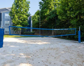 a tennis court with a blue net in front of a house