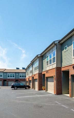 a parking lot with brick buildings and garages