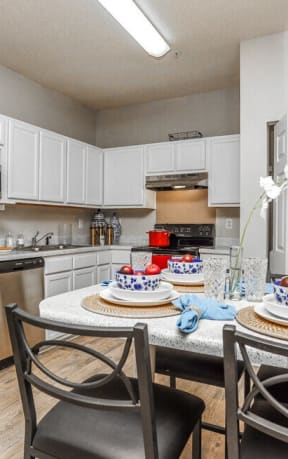 a kitchen with stainless steel appliances and a dining room table