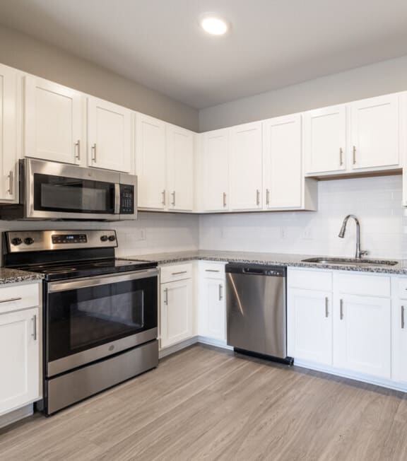 a kitchen with stainless steel appliances and white cabinets