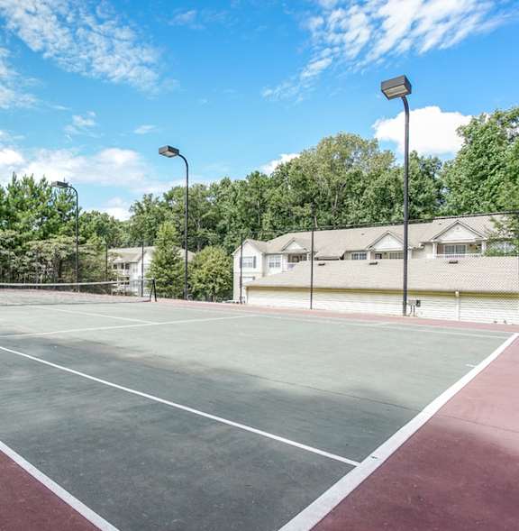 A tennis court with a net and trees in the background.