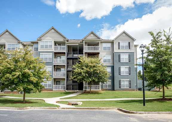 Apartment building with a green lawn in front.