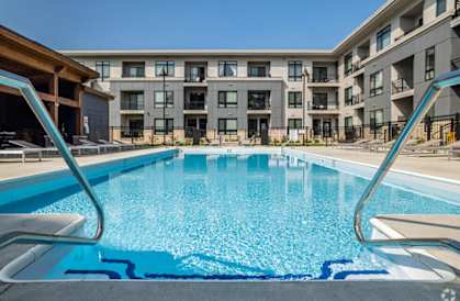 a swimming pool with an apartment building in the background at Two Points Crossing, Madison, WI, 53593
