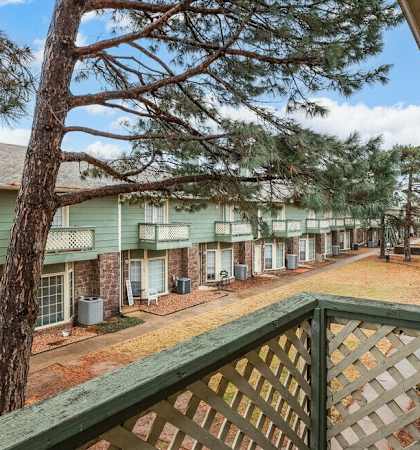 a view of a building from a balcony with a tree