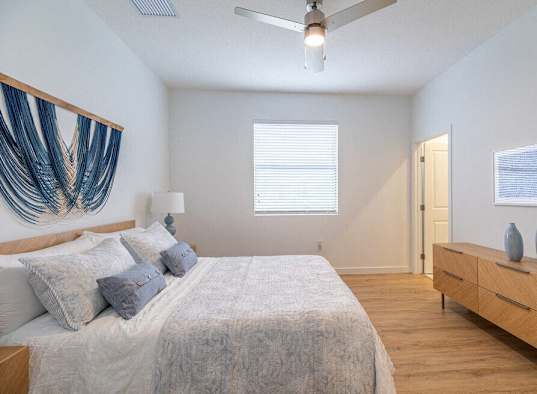 a bedroom with a large bed and a ceiling fan
