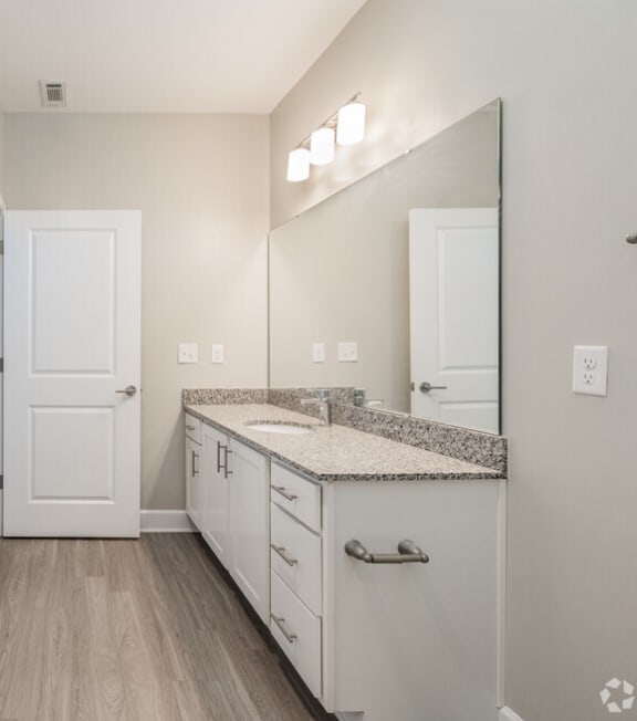 a bathroom with a shower and a sink and a mirror