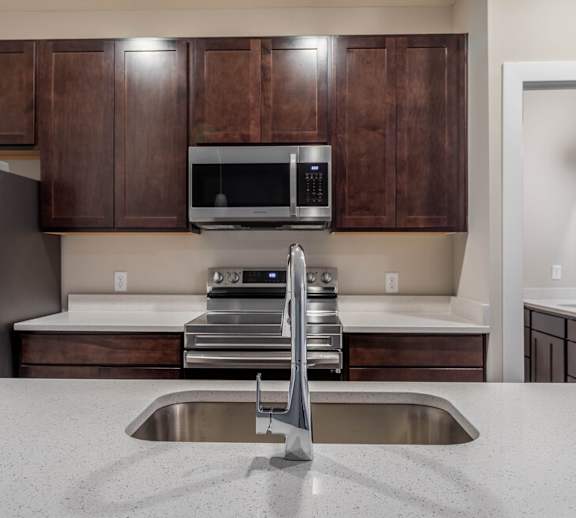 A kitchen with a sink and a microwave.