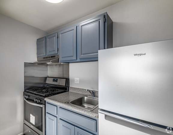 a kitchen with blue cabinets and stainless steel appliances