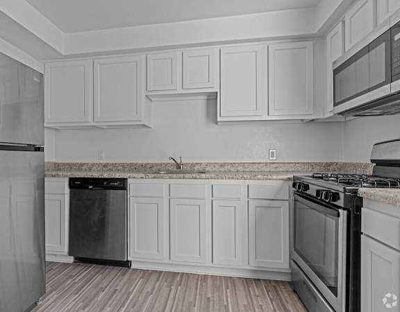 a kitchen with white cabinets and stainless steel appliances