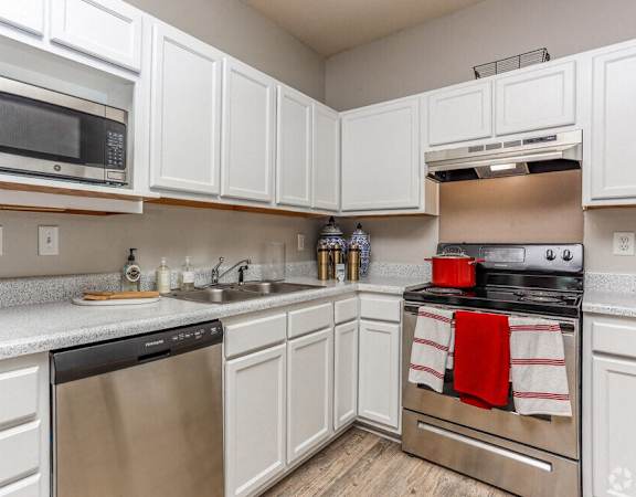 a kitchen with stainless steel appliances and white cabinets