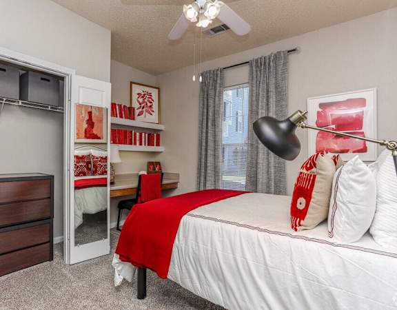 our guest bedroom has ample closet space and a red and white bed