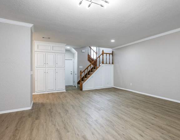 an empty living room with white walls and wood flooring