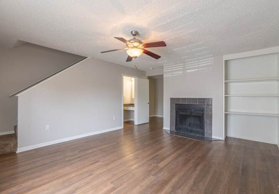 a living room with a fireplace and a ceiling fan