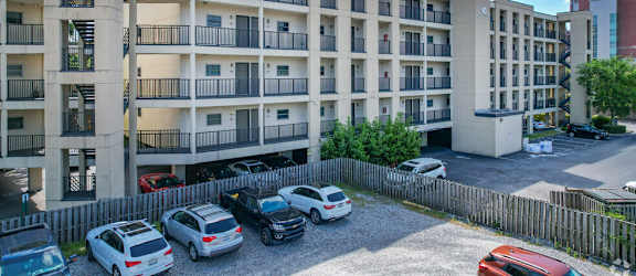 an image of an apartment building with cars parked in front