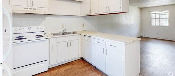 an empty kitchen with white appliances and white cabinets