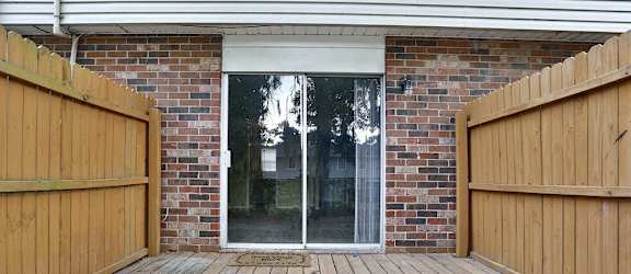 the deck of a brick house with a sliding glass door