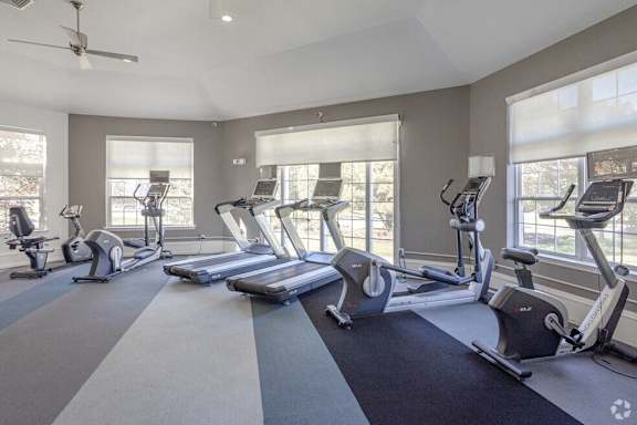 A spacious gym with treadmills and elliptical machines.