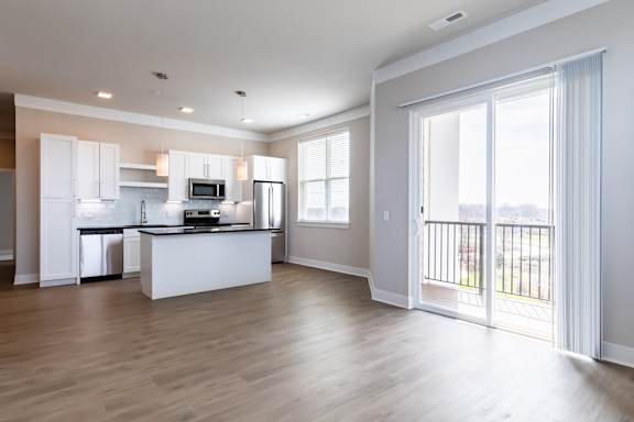 A spacious kitchen with white cabinets and a large island.