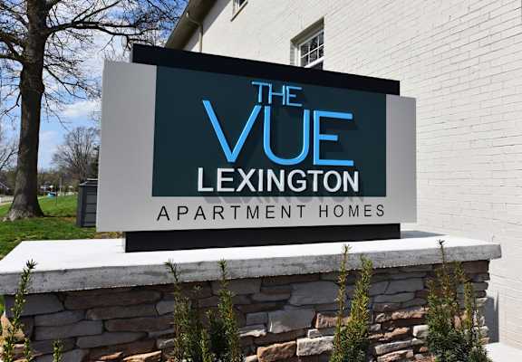 A sign for The Vue Lexington Apartment Homes sits in front of a building.