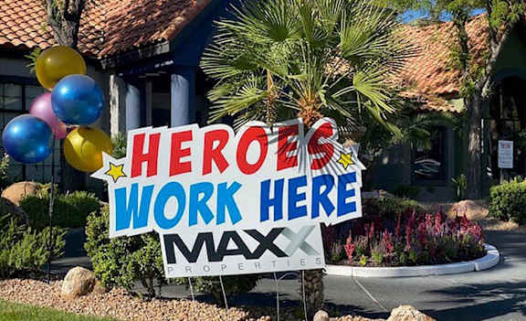 a heros work sign in front of a house with balloons