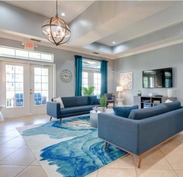 a living room with blue couches and a blue rug