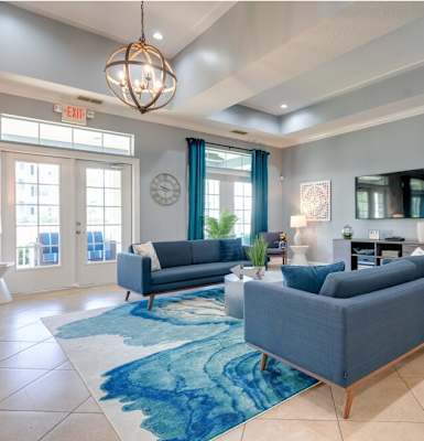 a living room with blue couches and a blue rug at Magnolia Village Apartments, Jacksonville, FL, 32207