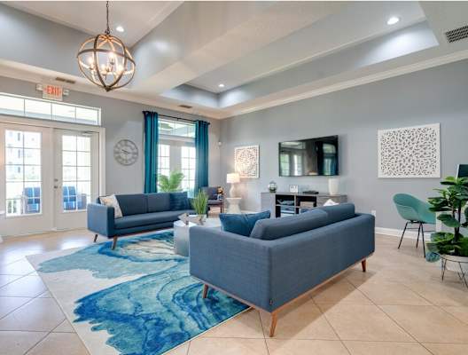 a living room with blue couches and a blue rug at Magnolia Village Apartments, Jacksonville, FL, 32207