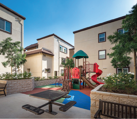 Playground area in between apartment buildings with picnic tables and bench-Parque Vista, Los Angeles, CA-Parque Vista, Los Angeles, CA