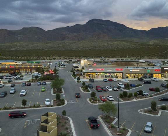 A parking lot with cars and a mountain in the background.