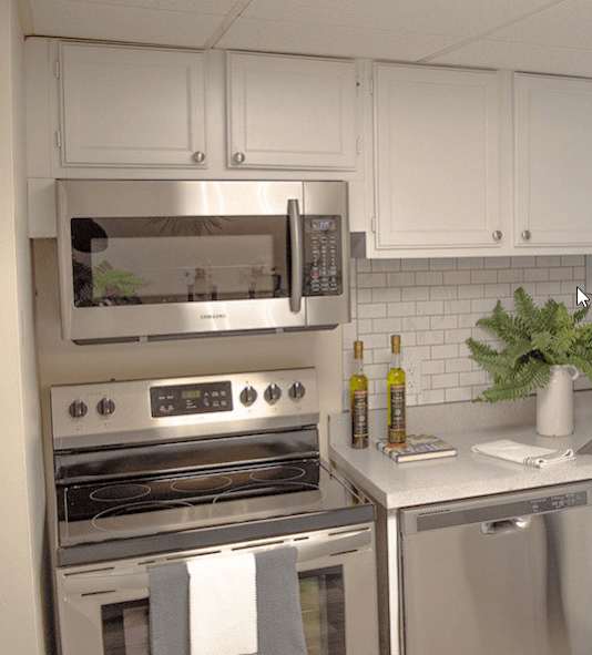 a bedroom with a bed and a kitchen and a living room