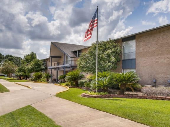 a flagpole in front of a building with a flag