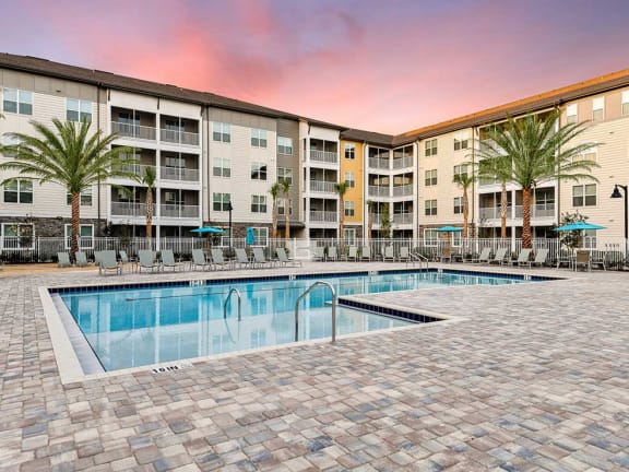 a swimming pool with an apartment building in the background