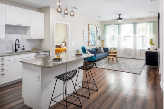 A modern kitchen with white cabinets and a marble backsplash at 19 South Apartments in Kissimmee