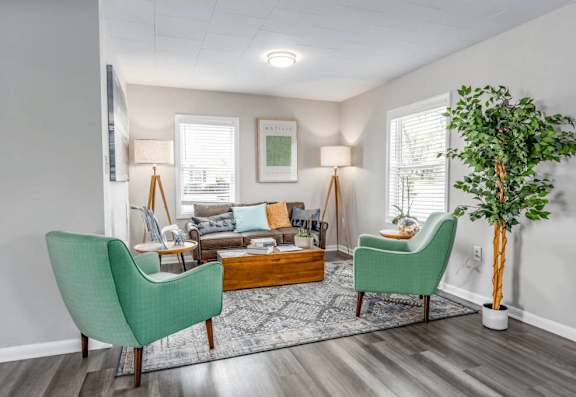 A living room with a green chair and a wooden coffee table.