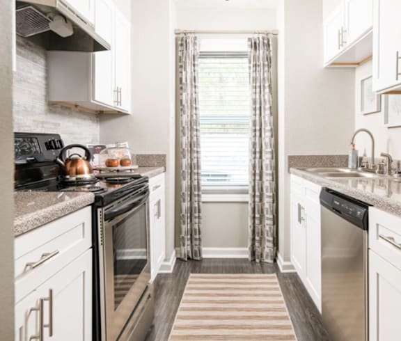 a kitchen with stainless steel appliances and white cabinets