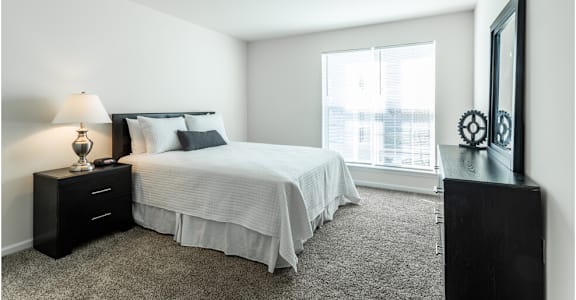 a bedroom with a bed and a large window