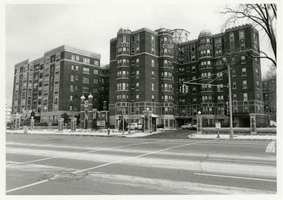 A black and white photo of a large apartment building.
