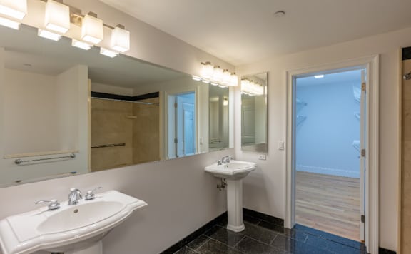 A bathroom with a white sink and mirror.