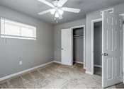 Thumbnail 4 of 13 - A room with a ceiling fan and three doors.